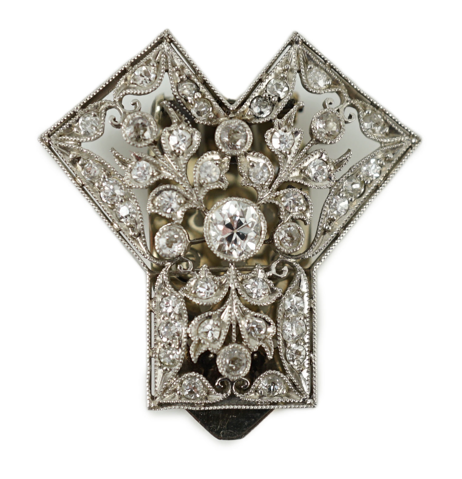A Belle Epoque pierced white gold and millegrain set diamond cluster set clip brooch